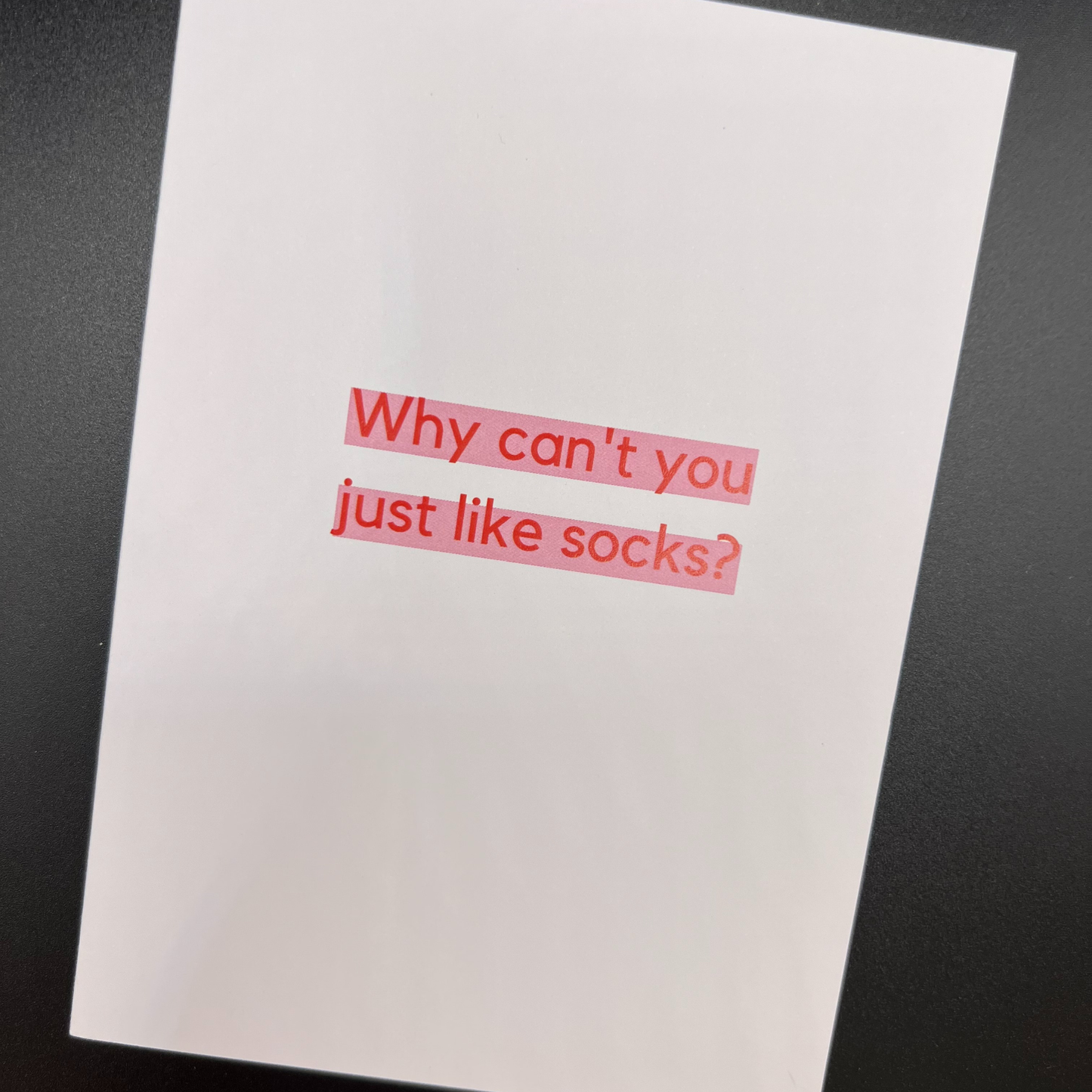 A white greeting card by The Mail Minx that says "Why can't you just like socks" in red text, which is highlighted in pink.