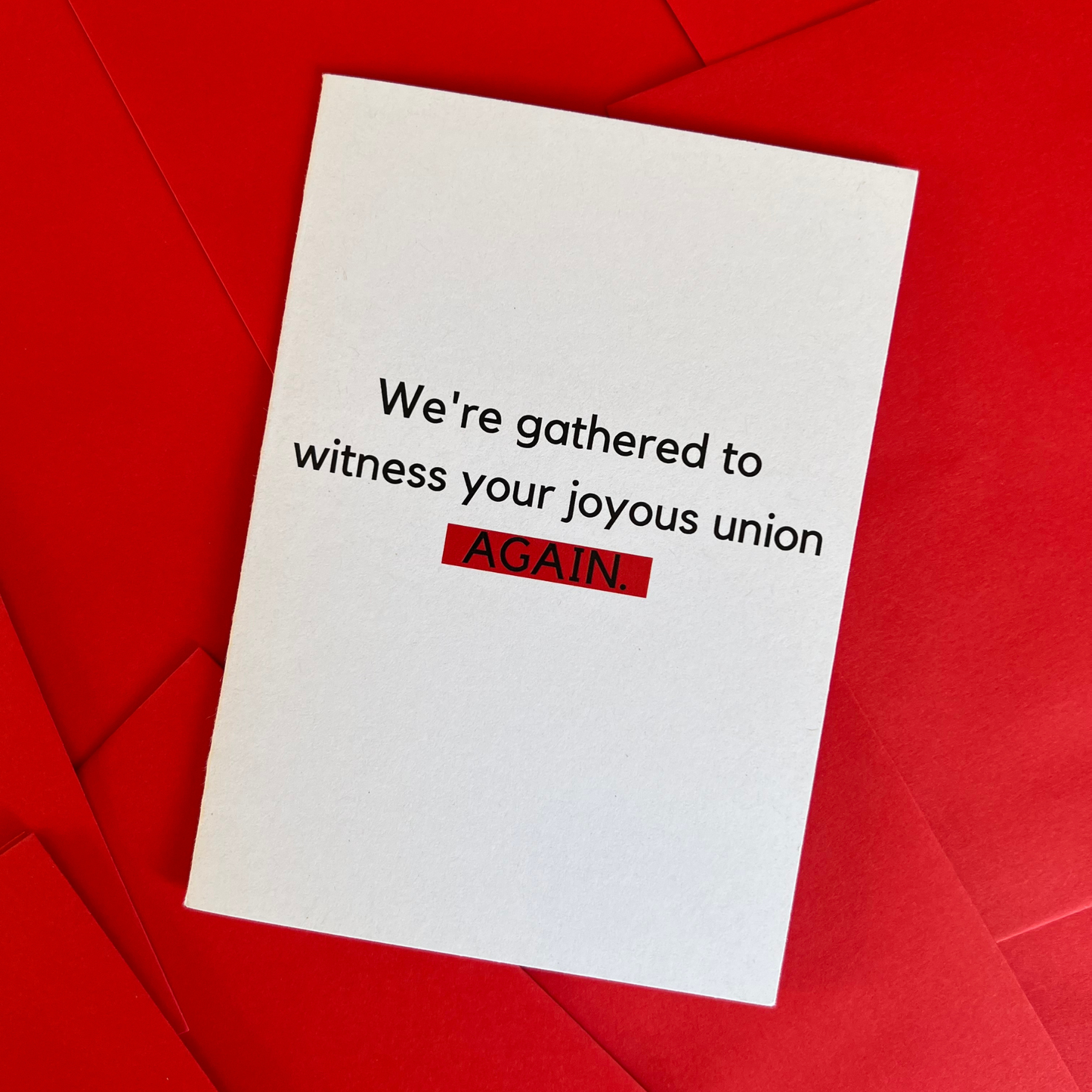 The Mail Minx wedding greeting card which is white and says "We're gathered to witness your joyous union AGAIN", in black. AGAIN is highlighted in red.