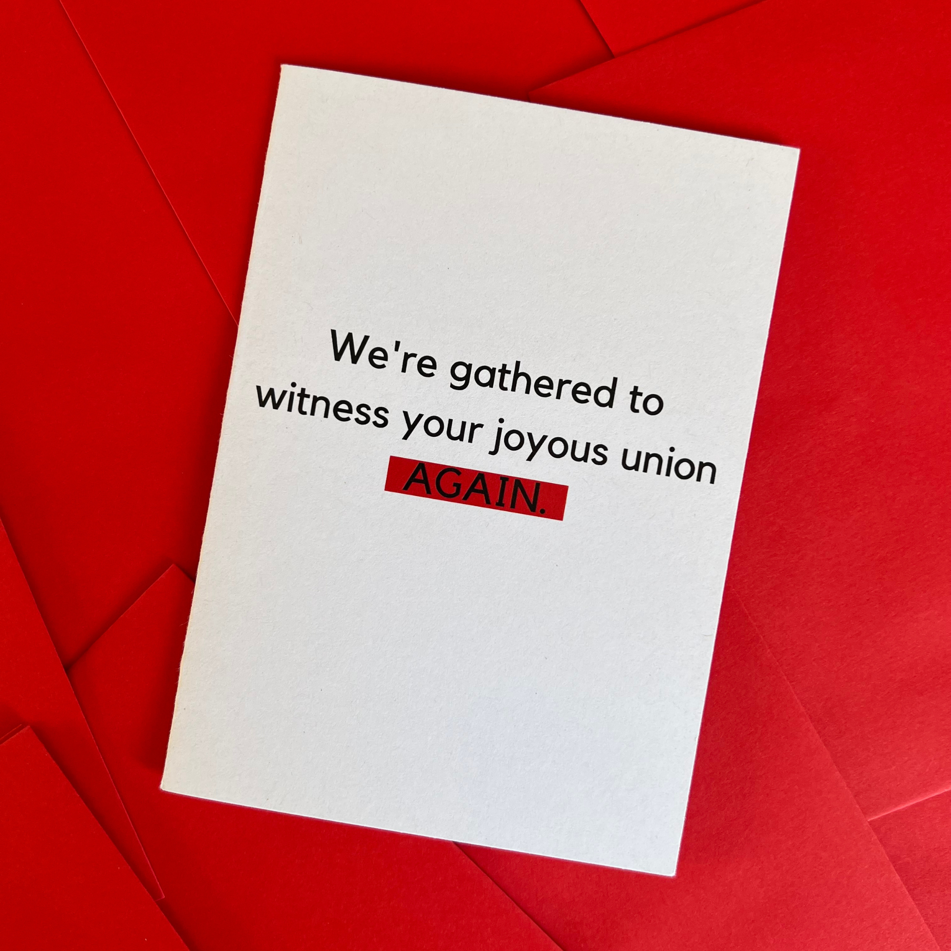 The Mail Minx wedding greeting card which is white and says "We're gathered to witness your joyous union AGAIN", in black. AGAIN is highlighted in red.
